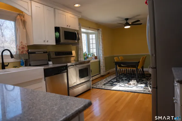 a kitchen with stainless steel appliances granite countertop a stove a refrigerator a kitchen island a stove and a microwave