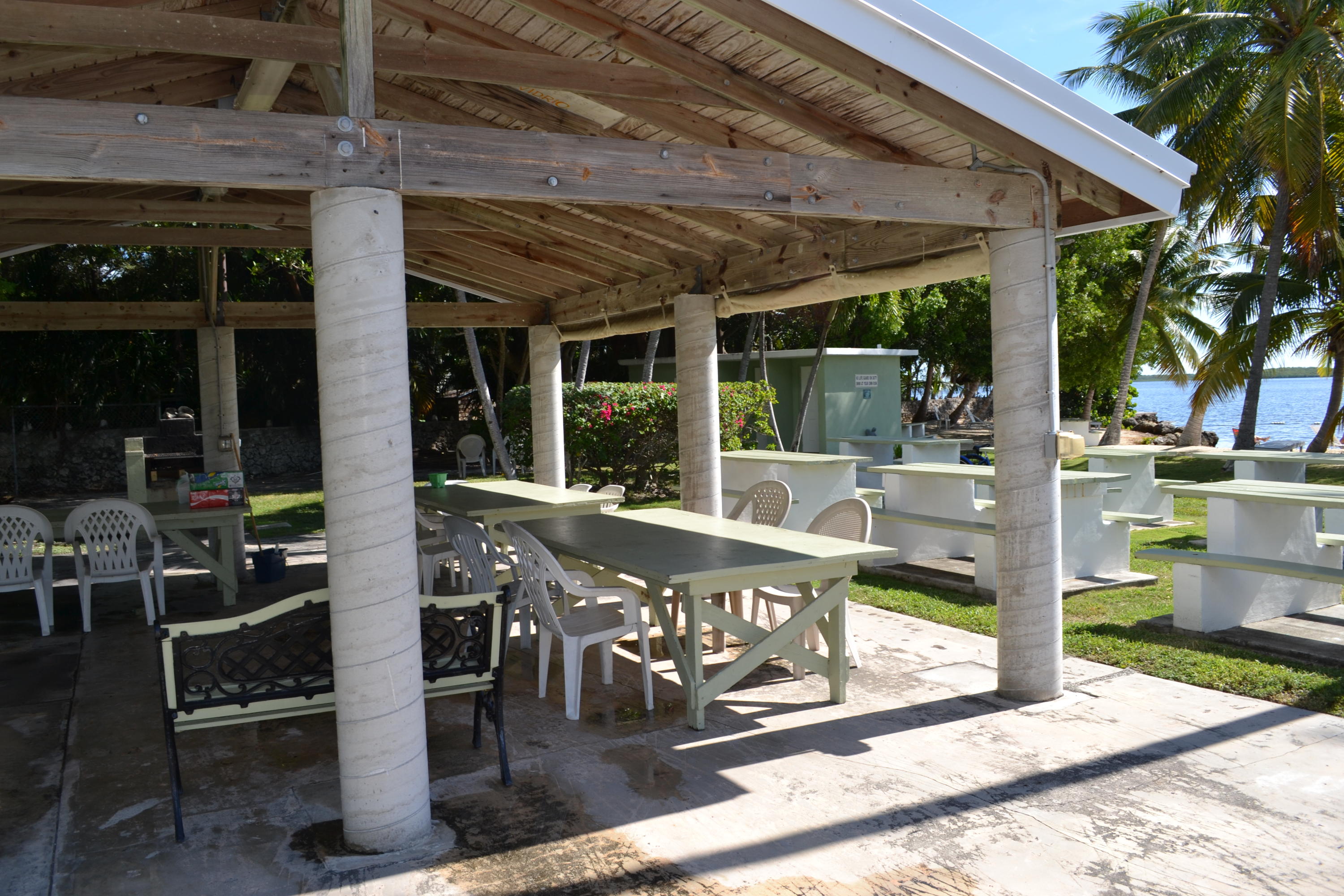 39 Bass Avenue Key Largo, FL 33037 - Photo 20 of 25 a view of a patio with table and chairs potted plants and floor to ceiling window