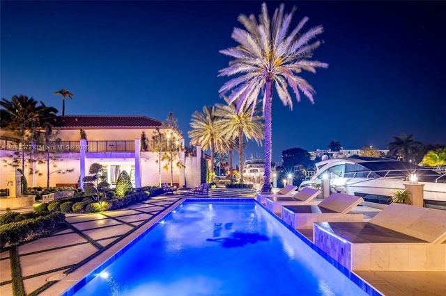 a view of a patio with couches table and chairs under an umbrella