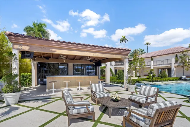 a front view of a house with swimming pool and furniture