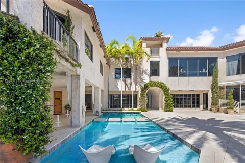 a living room with furniture and floor to ceiling windows