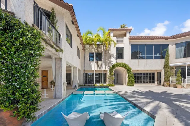 a living room with furniture and floor to ceiling windows