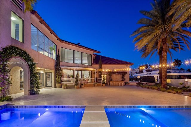 a front view of a house with a yard and potted plants