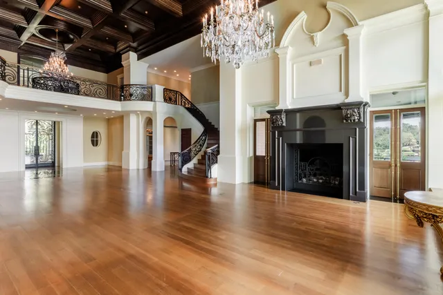 a view of a living room with kitchen island stainless steel appliances wooden floor and dining table