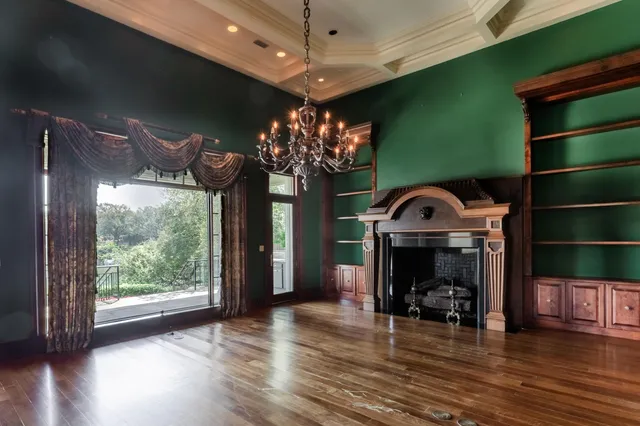 an empty room with wooden floor and a large window