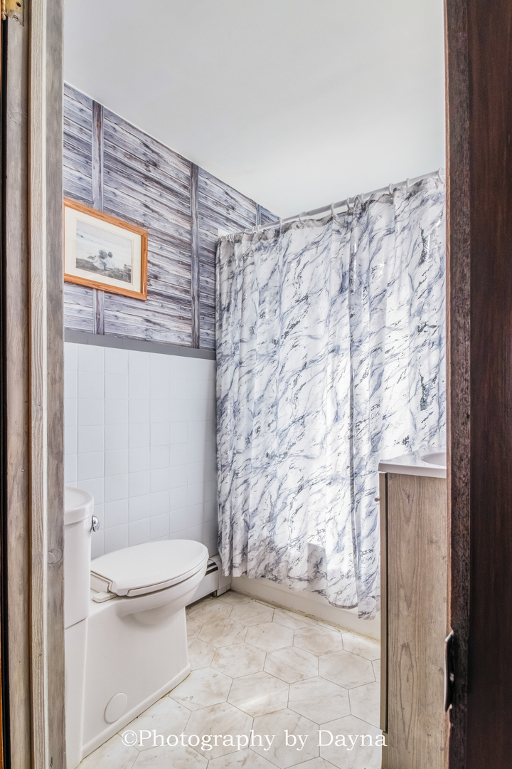 2857 River Road Kankakee, IL 60901 - Photo 21 of 35 a bathroom with a toilet and a shower curtain