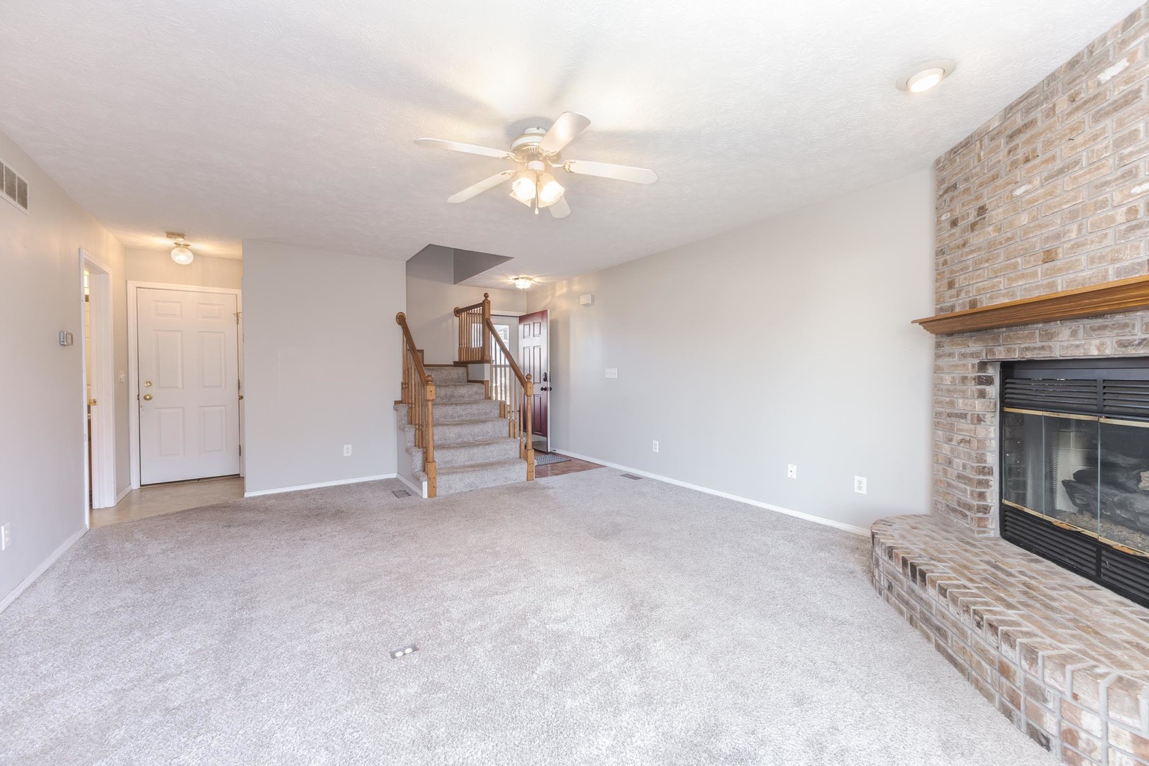 1321 Beacon Hill Court Normal, IL 61761 - Photo 6 of 45 an empty room with a fireplace and fan