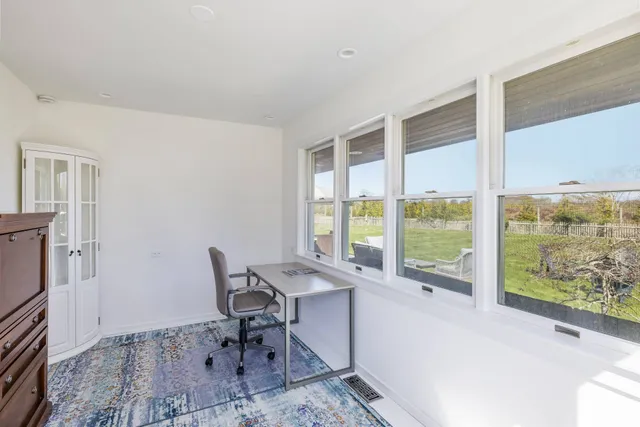 a view of a workspace with furniture and a window