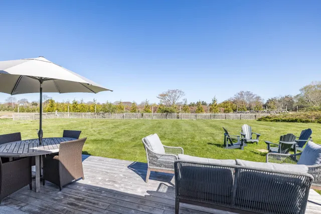 a view of a lake with couches in patio and lake view