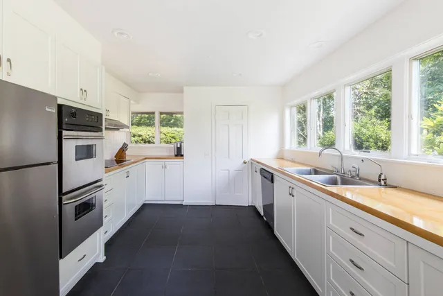 a kitchen with white cabinets and white appliances