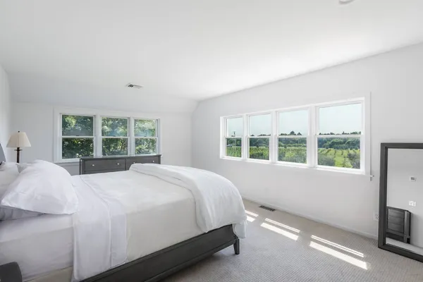 a large bed sitting in a bedroom next to a window