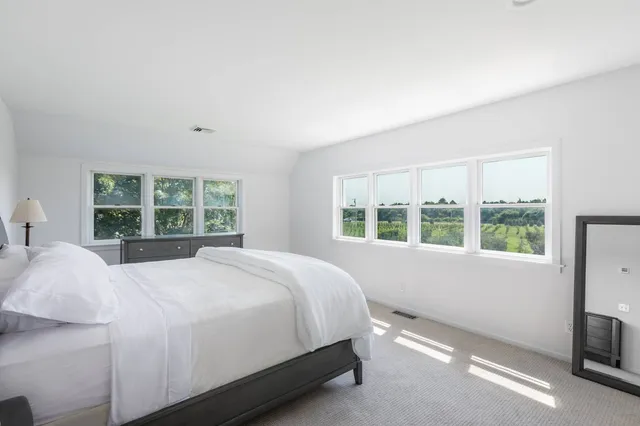 a large bed sitting in a bedroom next to a window