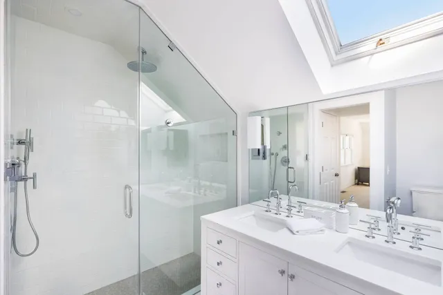a bathroom with a double vanity sink mirror and shower