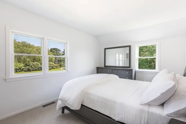 a bed sitting in a bedroom next to a window