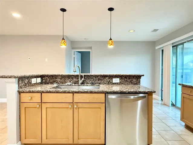 a kitchen with stainless steel appliances granite countertop a sink a stove and a wooden cabinets