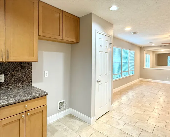 a view of hallway with granite countertop cabinets and wooden floor