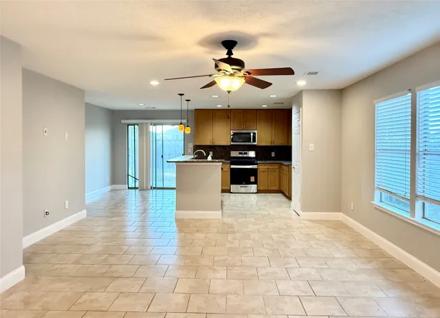 a view of a kitchen with a sink a refrigerator a fireplace and a workspace