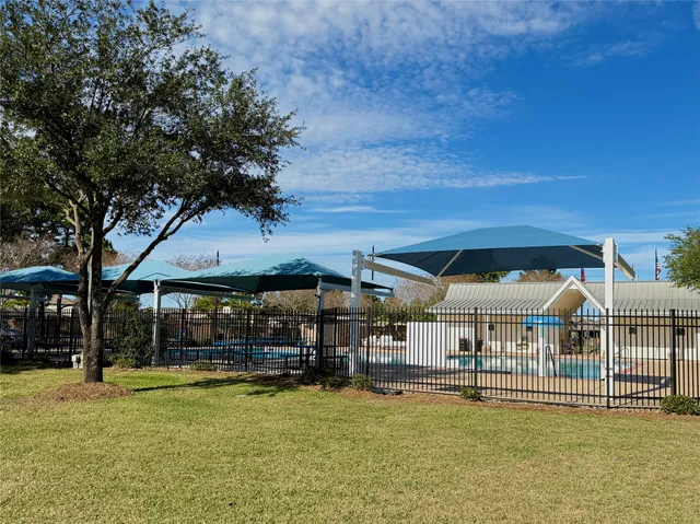 a view of a swimming pool with a table and chairs under an umbrella