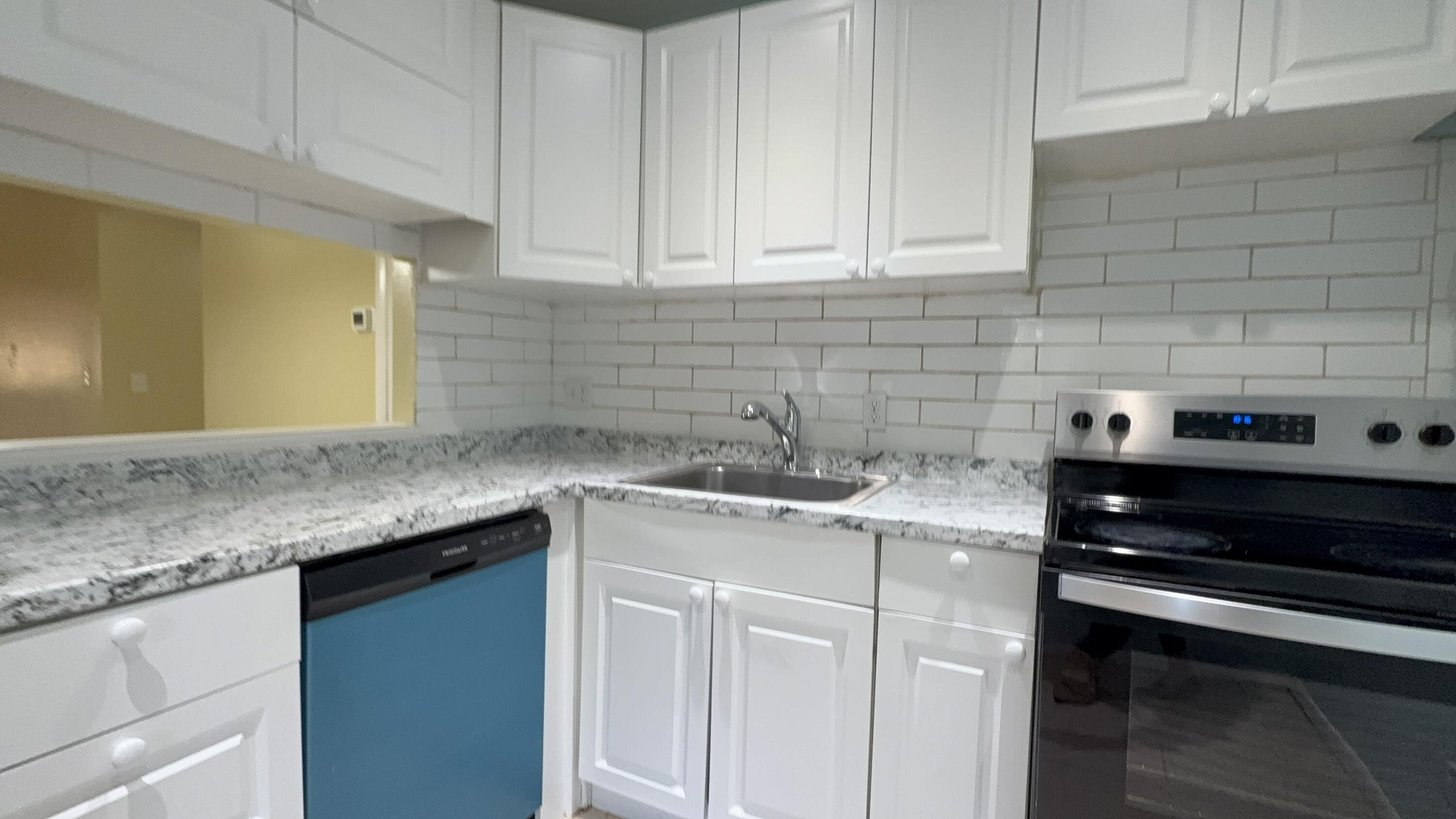 12009 Poinciana Boulevard, Unit 202 Royal Palm Beach, FL 33411 - Photo 1 of 24 a kitchen with stainless steel appliances granite countertop a sink stove and cabinets