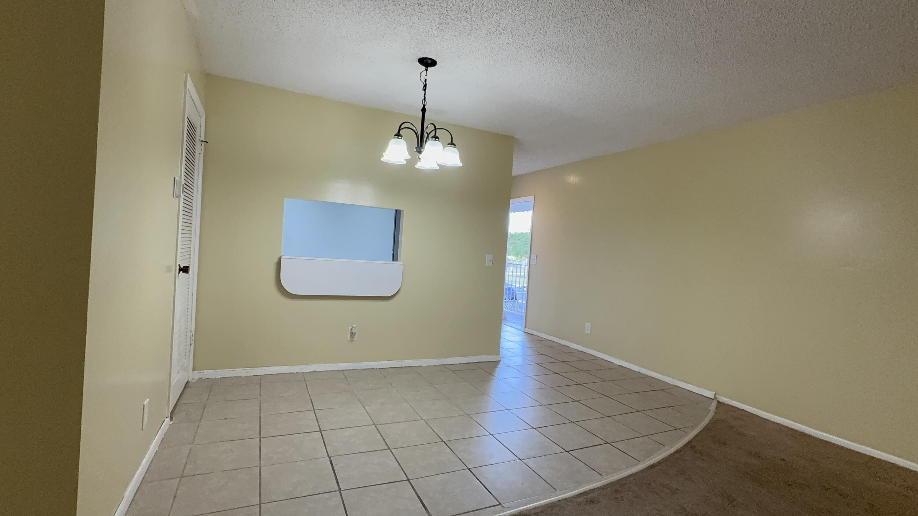 12009 Poinciana Boulevard, Unit 202 Royal Palm Beach, FL 33411 - Photo 11 of 24 a view of a livingroom with a chandelier