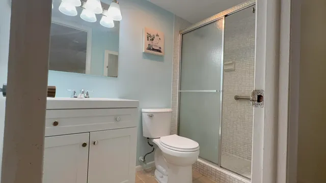 a white toilet sitting next to a shower