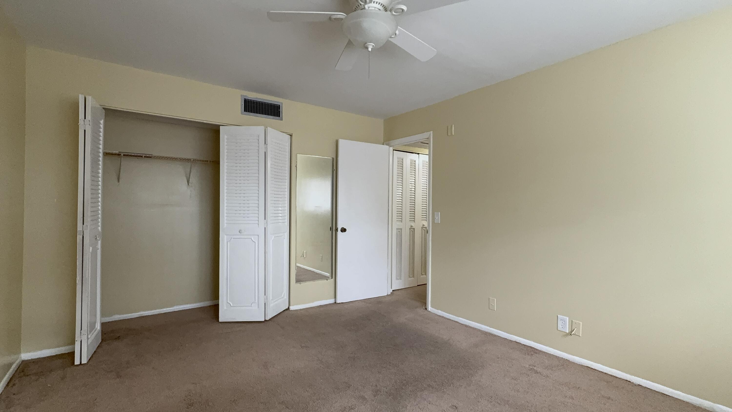 12009 Poinciana Boulevard, Unit 202 Royal Palm Beach, FL 33411 - Photo 20 of 24 an empty room with a ceiling fan and a bathroom