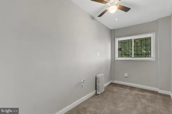 an empty room with a window and a fan