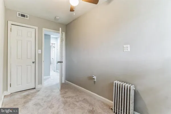 an empty room with a ceiling fan and a window