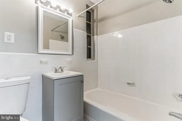 a bathroom with a bathtub sink and mirror