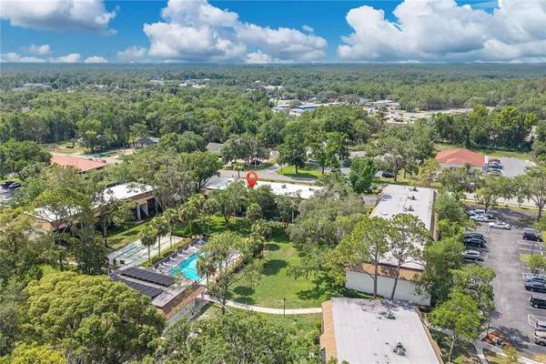 an aerial view of residential houses with outdoor space and trees