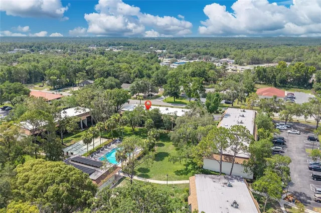 an aerial view of residential houses with outdoor space and trees