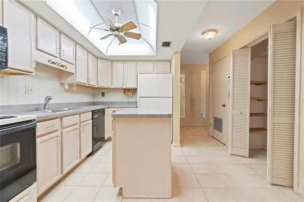 a view of a big room with a chandelier fan and windows