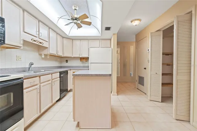 a view of a big room with a chandelier fan and windows