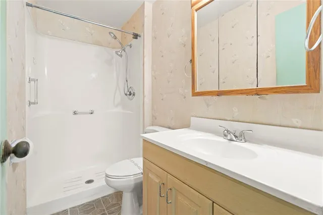 a view of a livingroom with an empty space and a ceiling fan