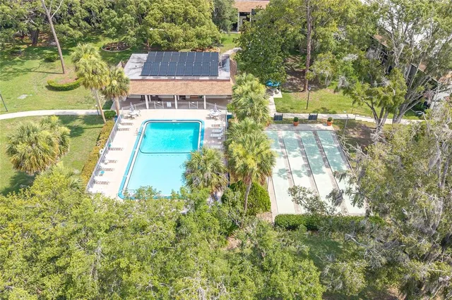 an aerial view of residential houses with outdoor space and trees