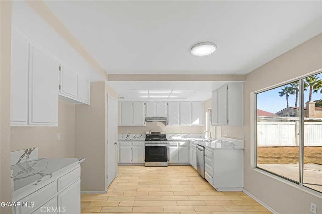 44910 12th Street East Lancaster, CA 93535 - Photo 13 of 47 a kitchen with granite countertop a refrigerator sink and cabinets