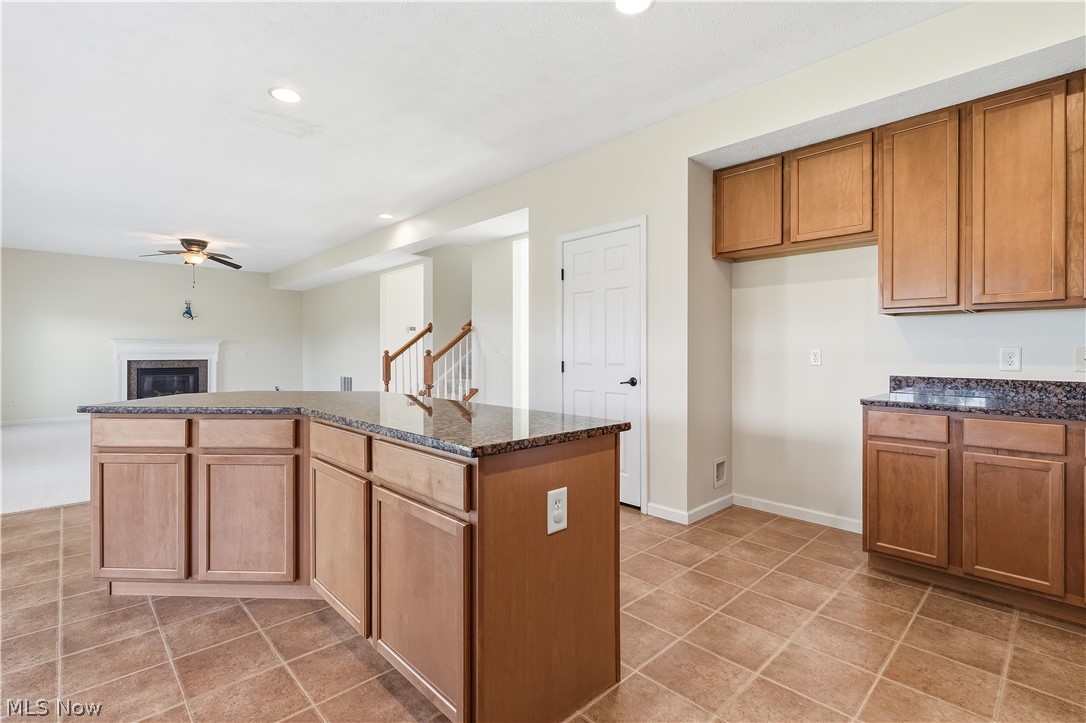 3280 Seven Bridges Road Medina, OH 44256 - Photo 14 of 41 Kitchen featuring a central island with a stone countertop, wood cabinetry, and tile flooring