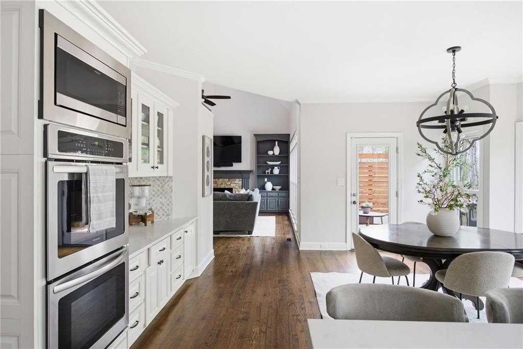 5335 Cottage Farm Road Johns Creek, GA 30022 - Photo 12 of 60 a kitchen with stainless steel appliances granite countertop a stove top oven a sink dishwasher a dining table and chairs with wooden floor