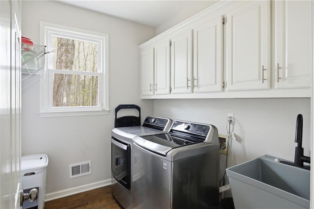 5335 Cottage Farm Road Johns Creek, GA 30022 - Photo 18 of 60 a utility room with stainless steel appliances granite countertop a sink a stove a window and a window