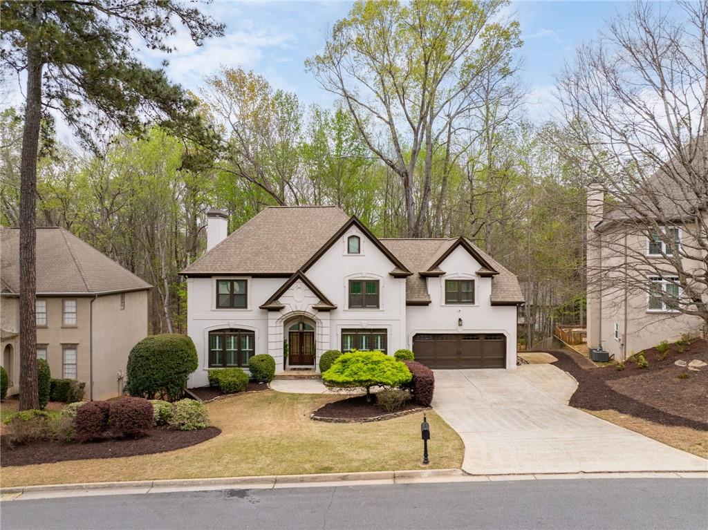 5335 Cottage Farm Road Johns Creek, GA 30022 - Photo 41 of 60 a front view of a house with a garden and trees