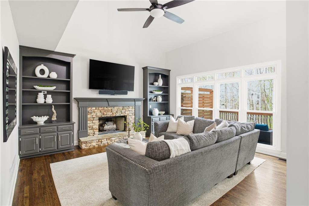 5335 Cottage Farm Road Johns Creek, GA 30022 - Photo 7 of 60 a living room with furniture a fireplace and a flat screen tv