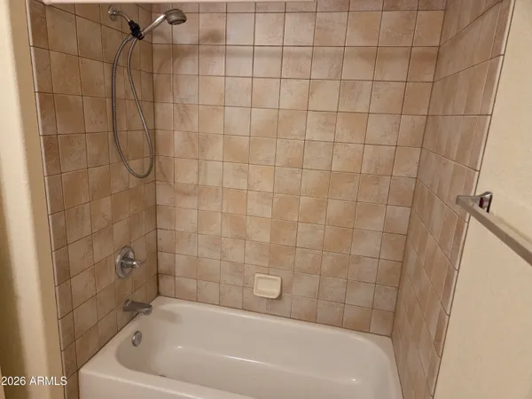 a bathroom with a white bath tub and shower
