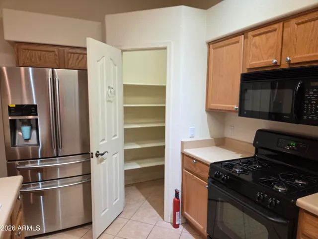 a kitchen with granite countertop a refrigerator stove and microwave