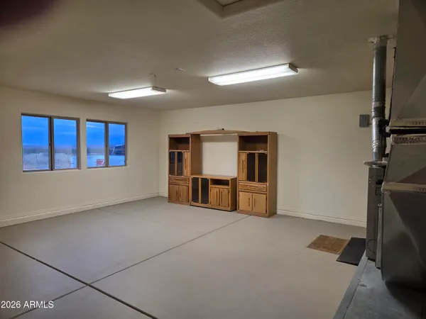 a view of an empty room with closet and a window