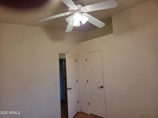 a view of an empty room and chandelier fan