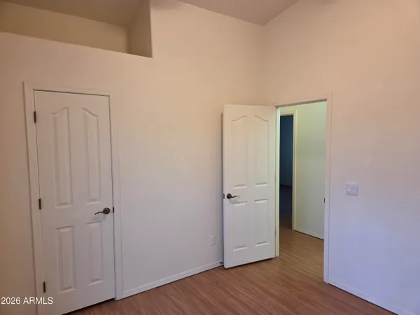 an empty room with wooden floor and closet area