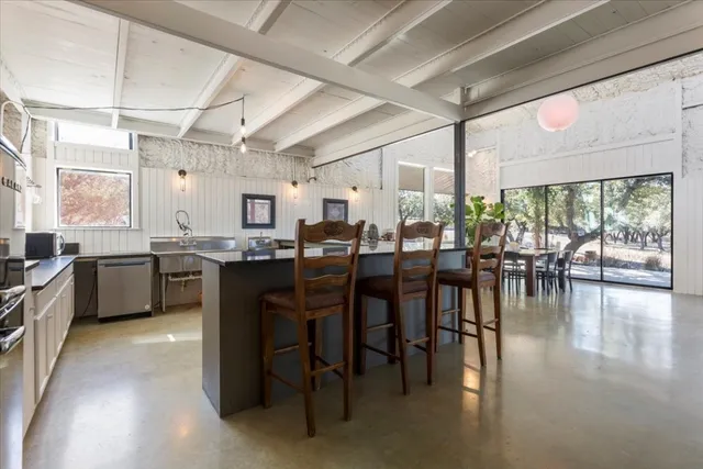 a view of a patio with table and chairs and couches with wooden floor and fence