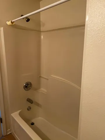 a white toilet sitting next to a white wall