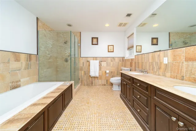 a spacious bathroom with a double vanity sink a large mirror and a bathtub