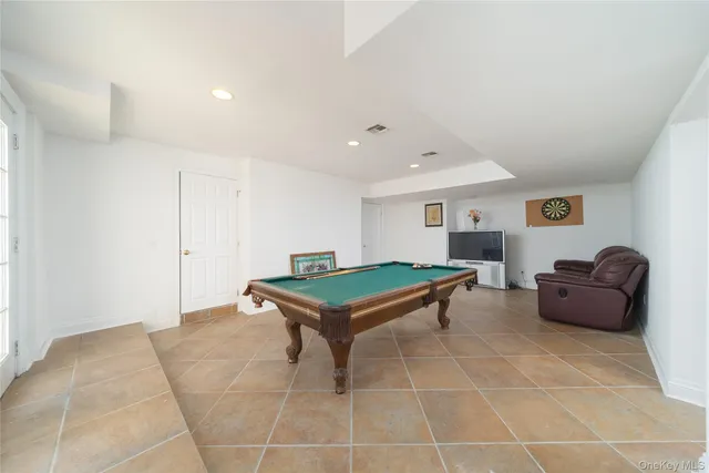 a room with furniture pool table and windows